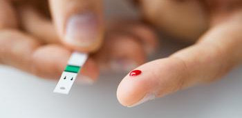 Dedo con sangre haciendo prueba de la diabetes mellitus