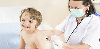 Una médico auscultando a un niño