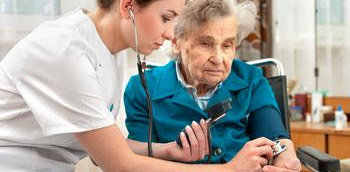 Doctora en urgencias auscultando con una paciente anciana