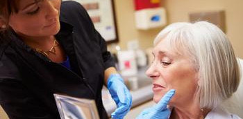 Doctora inyectando toxina botulínica a una señora en una intervención estética