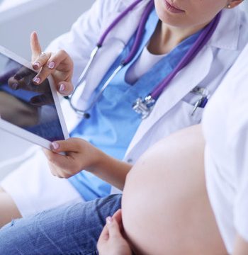 Doctora explicando a una mujer embarazada una ecografía