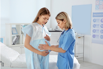 Doctora asistiendo a una mujer embarazada