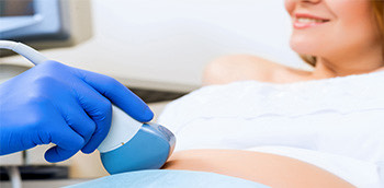 Doctor realizando ecografía a mujer embarazada
